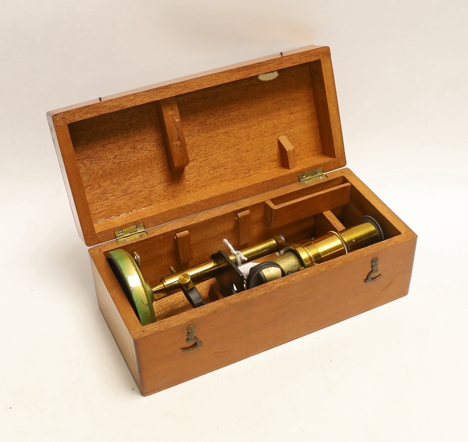 A brass monocular student’s microscope in fitted teak case, case 22cm